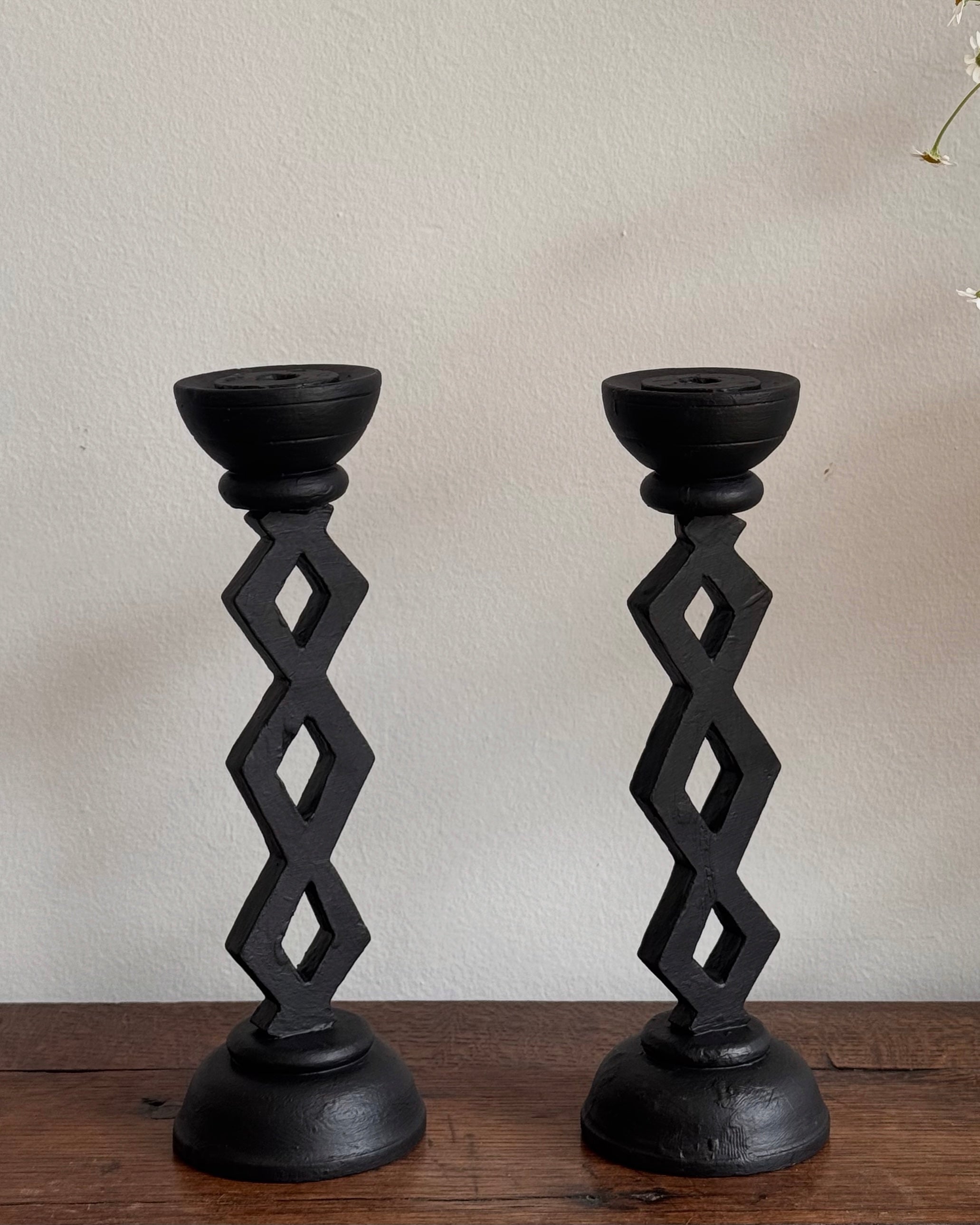 Pair of black wooden candle holders with diamond pattern