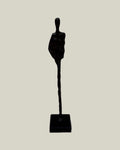Metal human sculpture on one leg