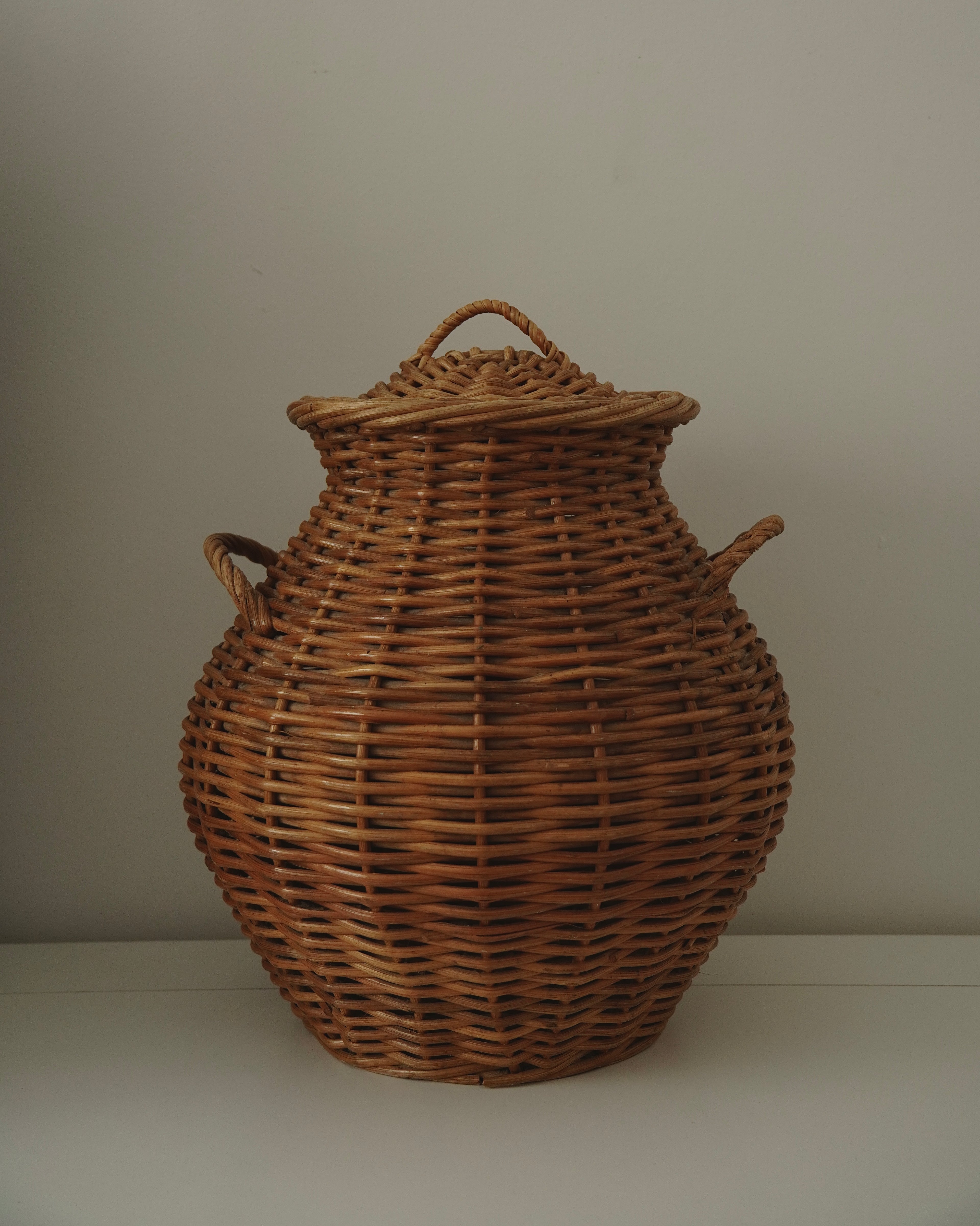 Cane urn-form woven laundry basket with handles and lid