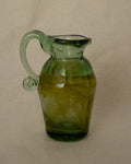 Green art glass jug vase with spiral handle and yellow accents