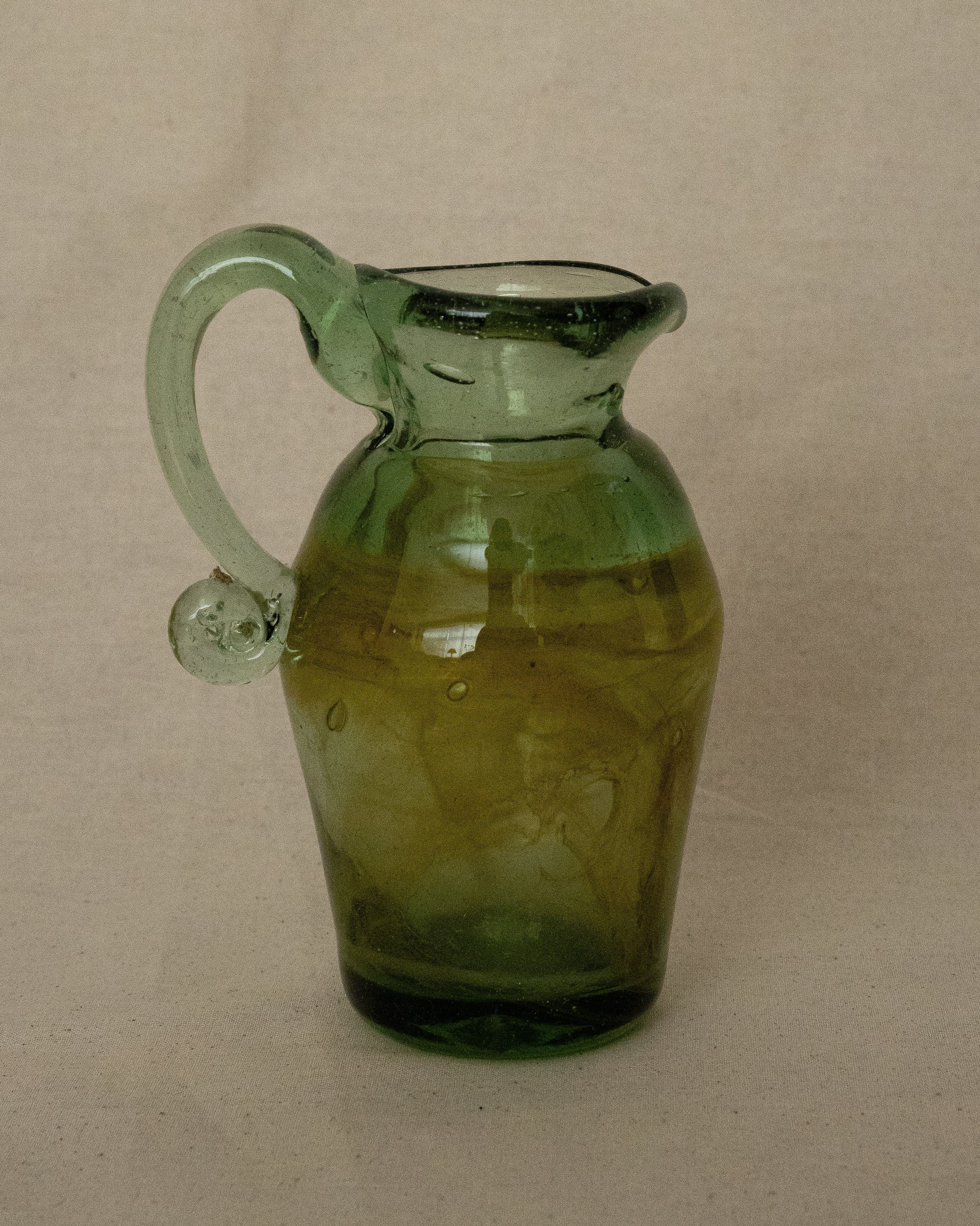 Green art glass jug vase with spiral handle and yellow accents