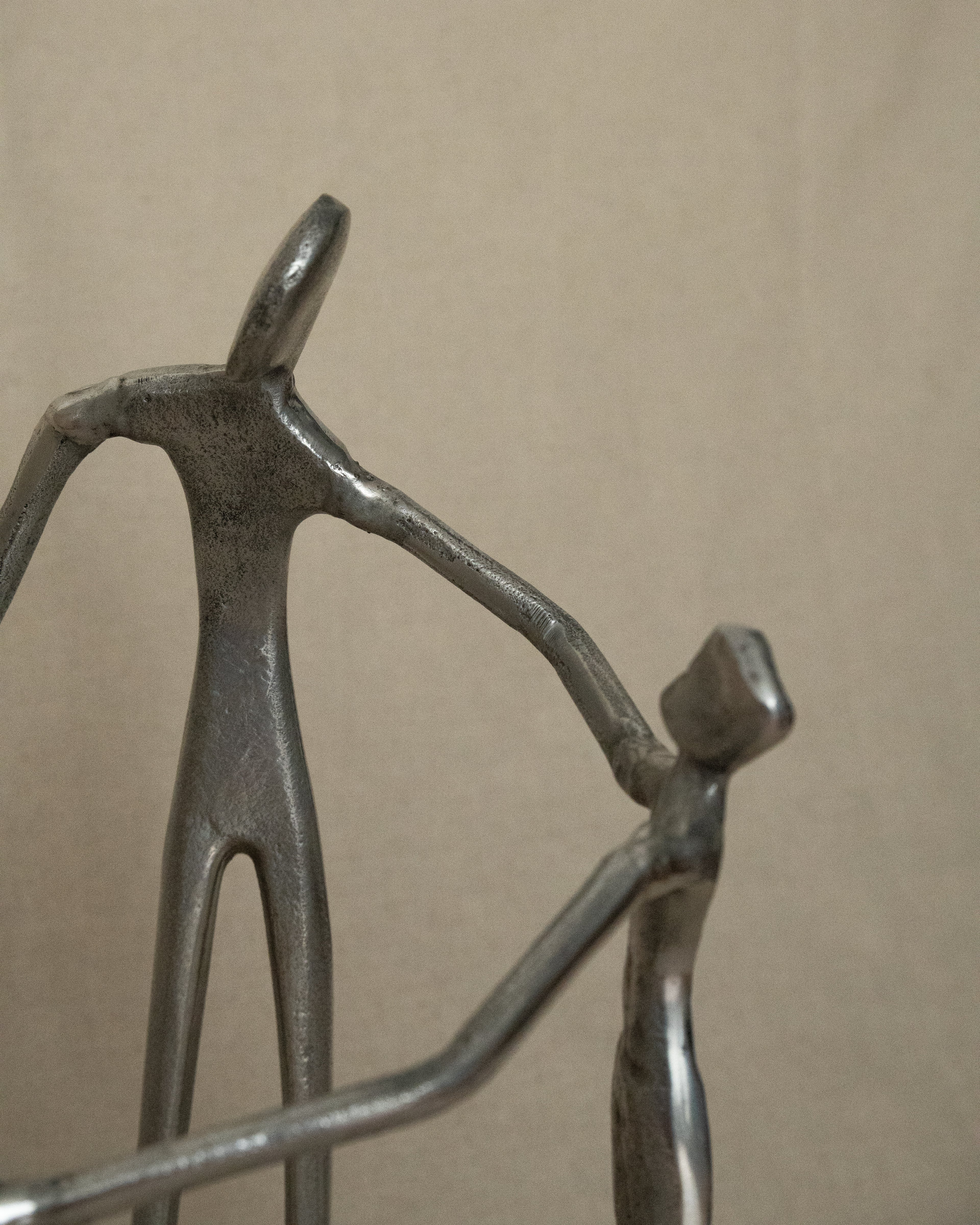 4 aluminum humans holding hands in a circle