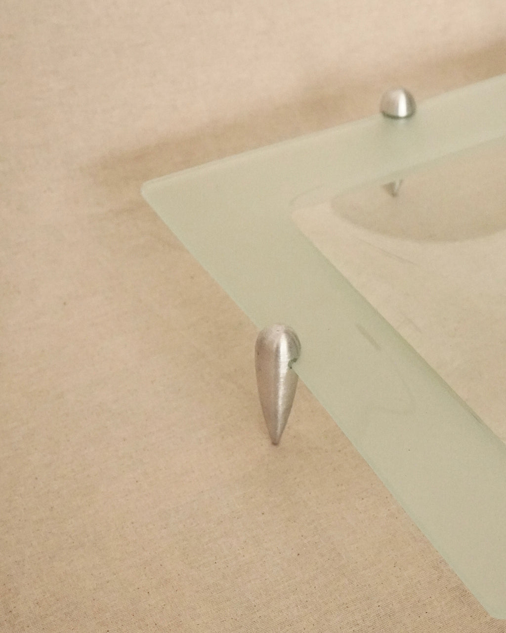 Glass square dish raised by atomic silver feet