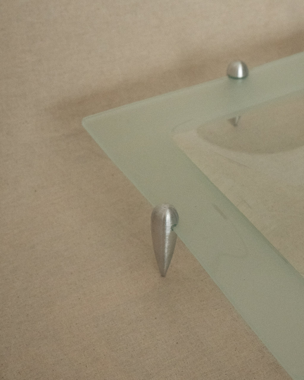 Glass square dish raised by atomic silver feet