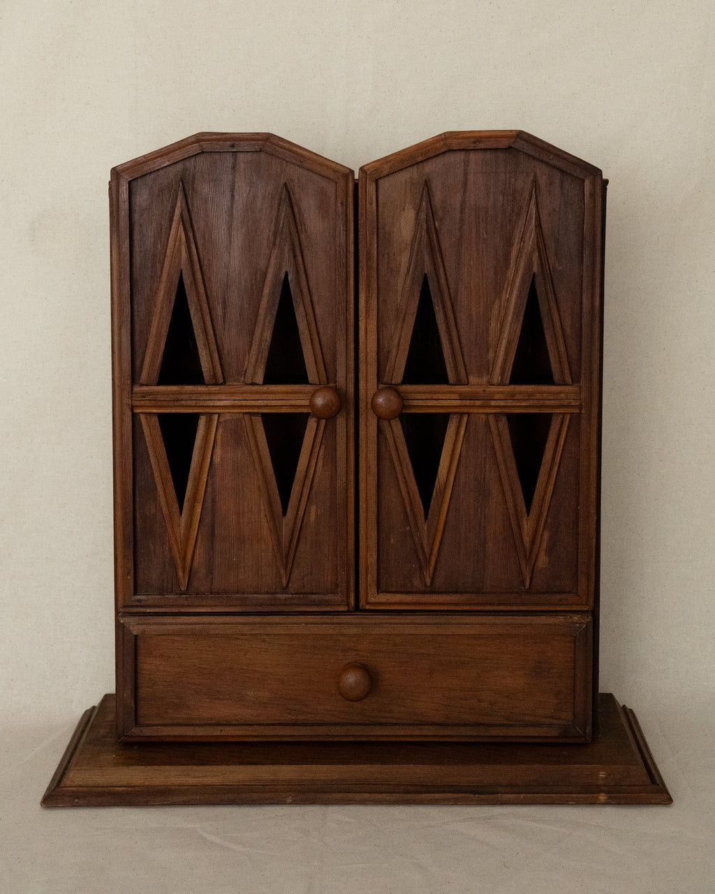 Wooden gothic style cabinet with shelving, two doors and a drawer