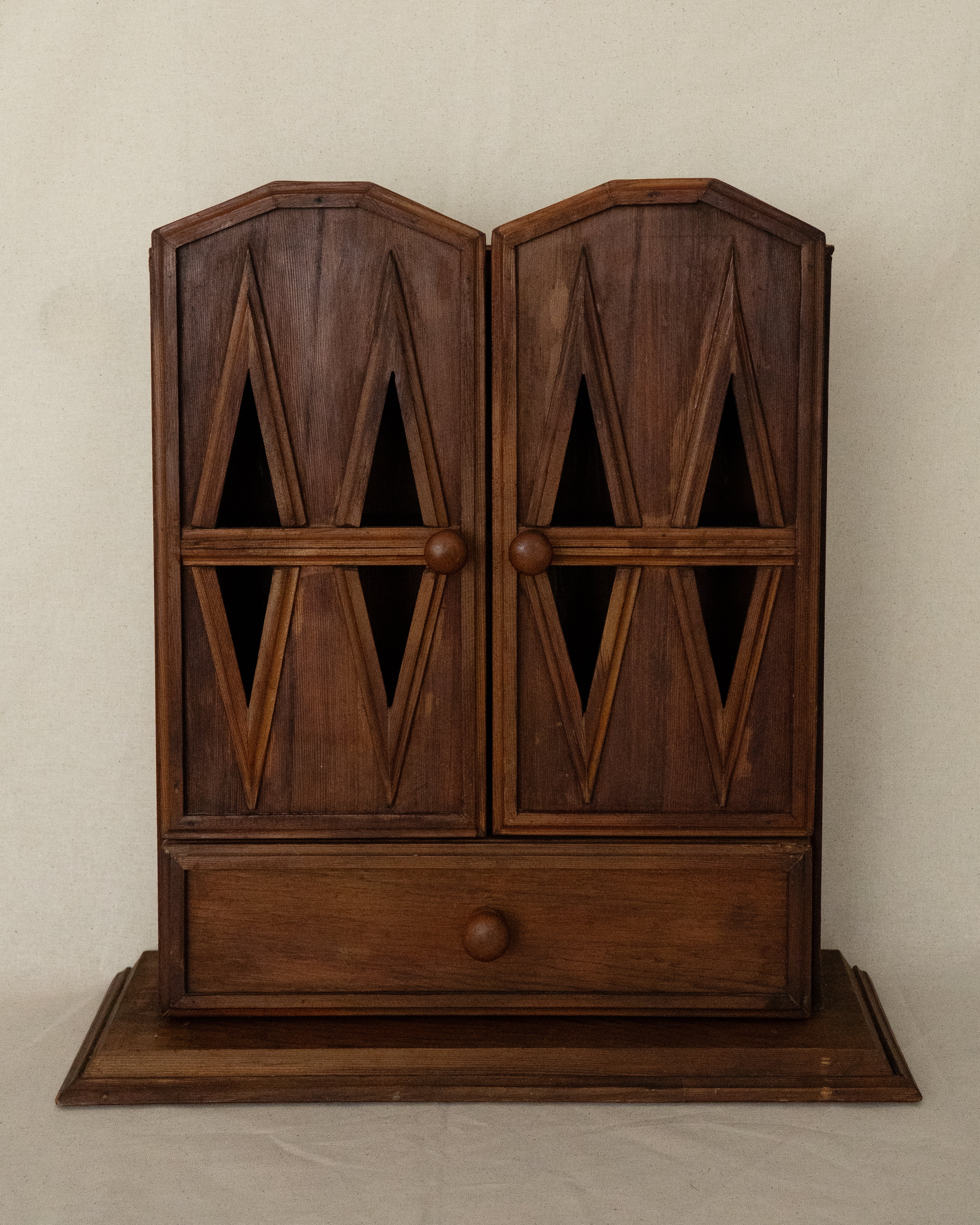 Wooden gothic style cabinet with shelving, two doors and a drawer