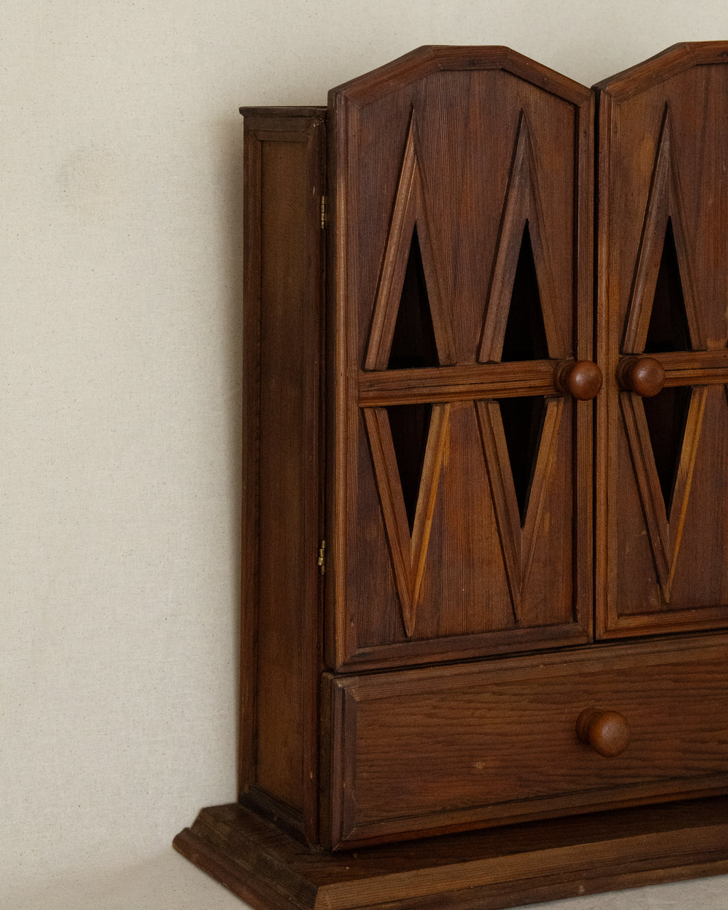 Wooden gothic style cabinet with shelving, two doors and a drawer