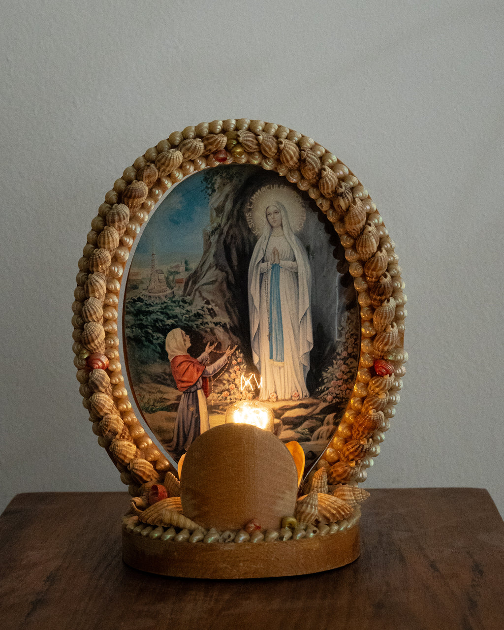 Shell table lamp encasing religious scene