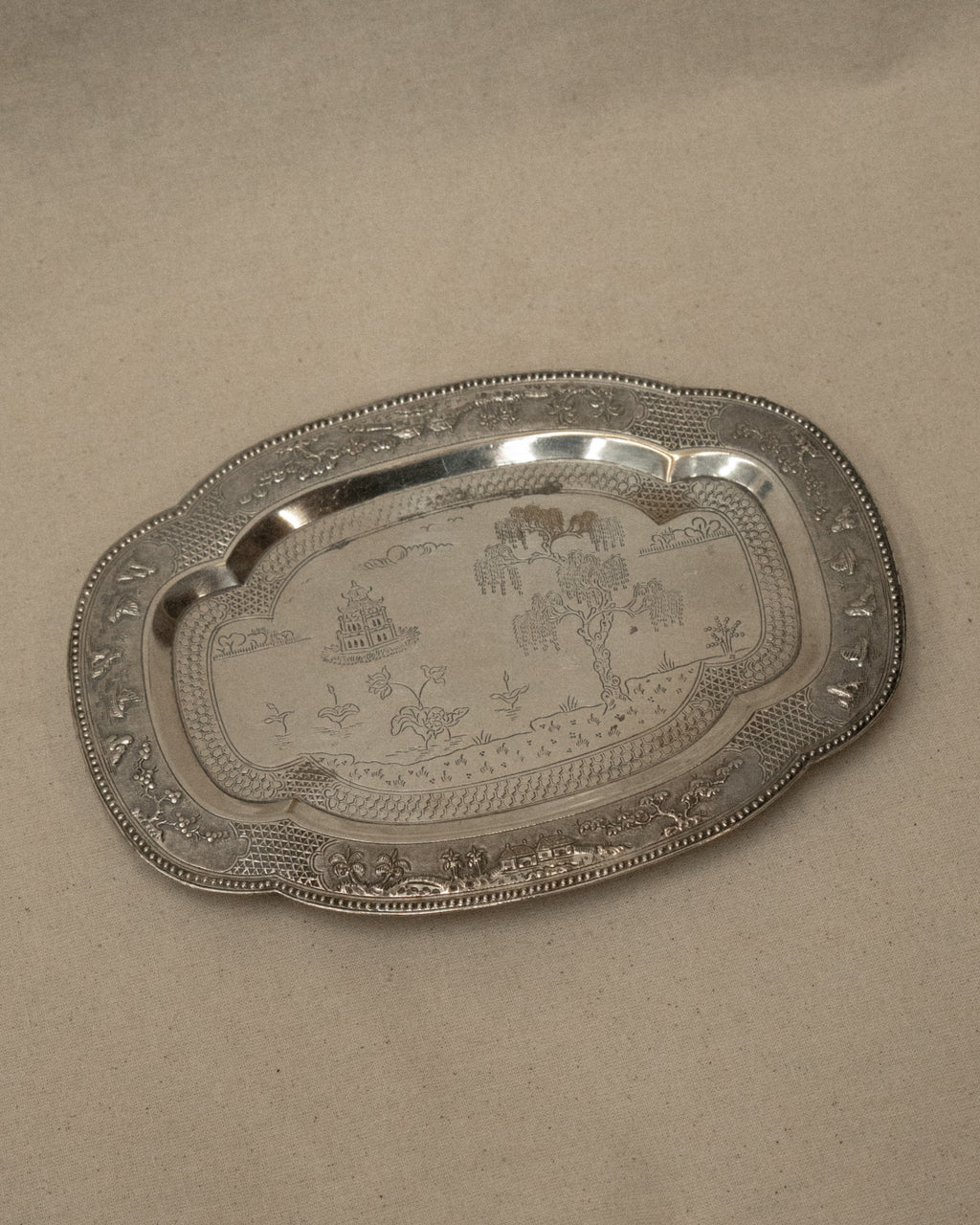 Metal tray with temple and tree engravings on feet