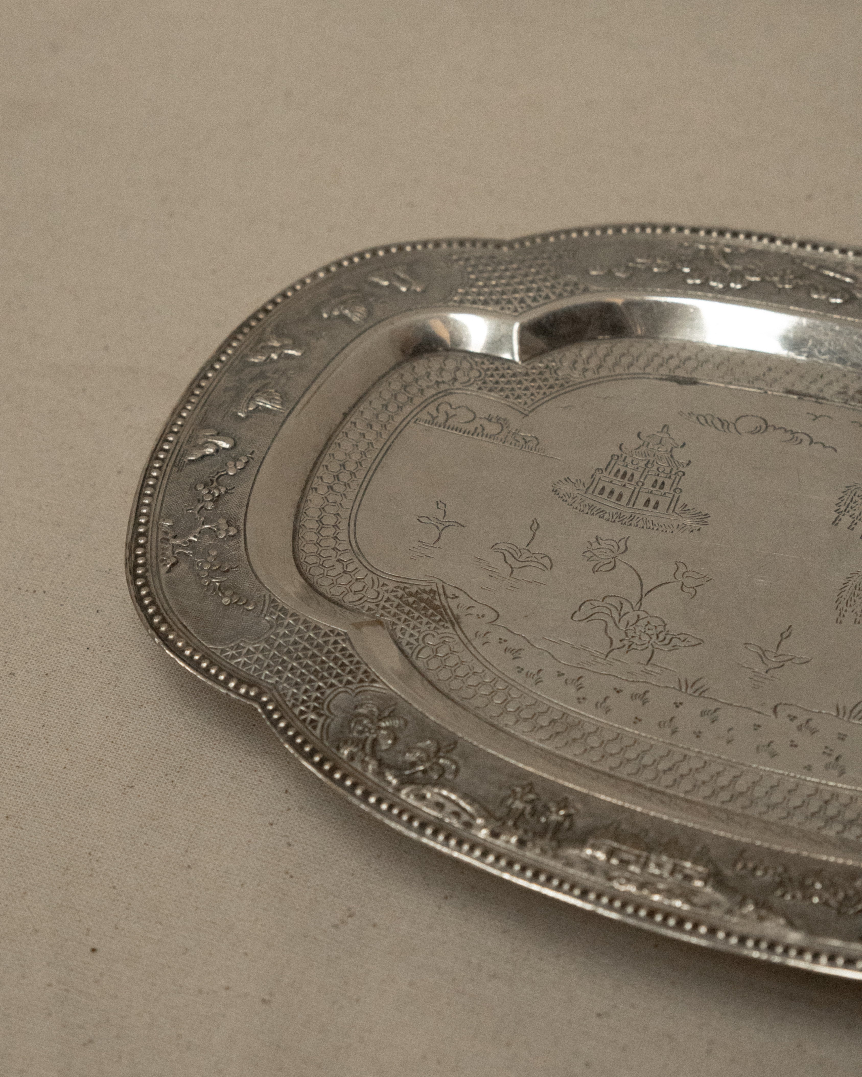 Metal tray with temple and tree engravings on feet