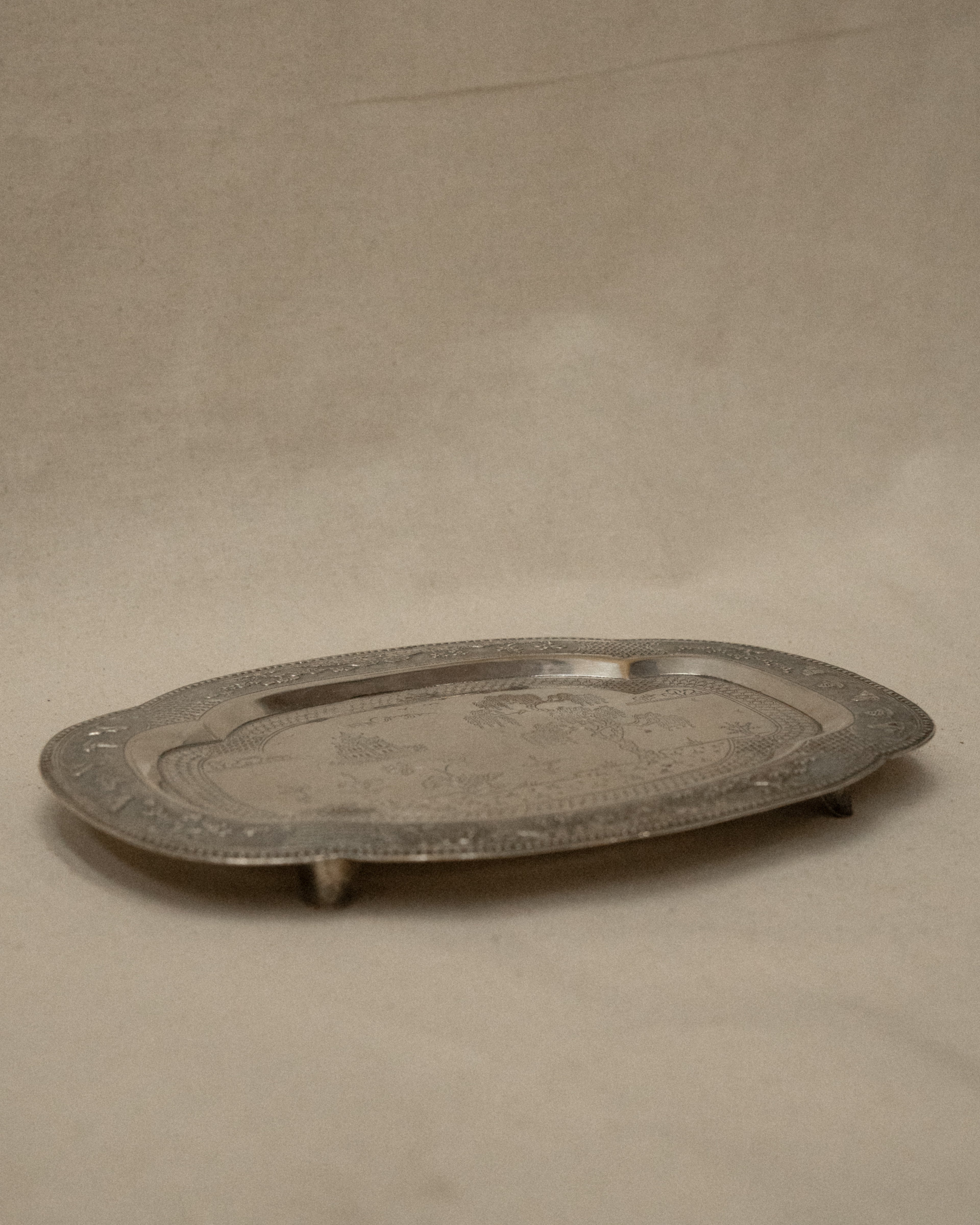 Metal tray with temple and tree engravings on feet