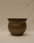 Brass plant pot that hangs on a wall