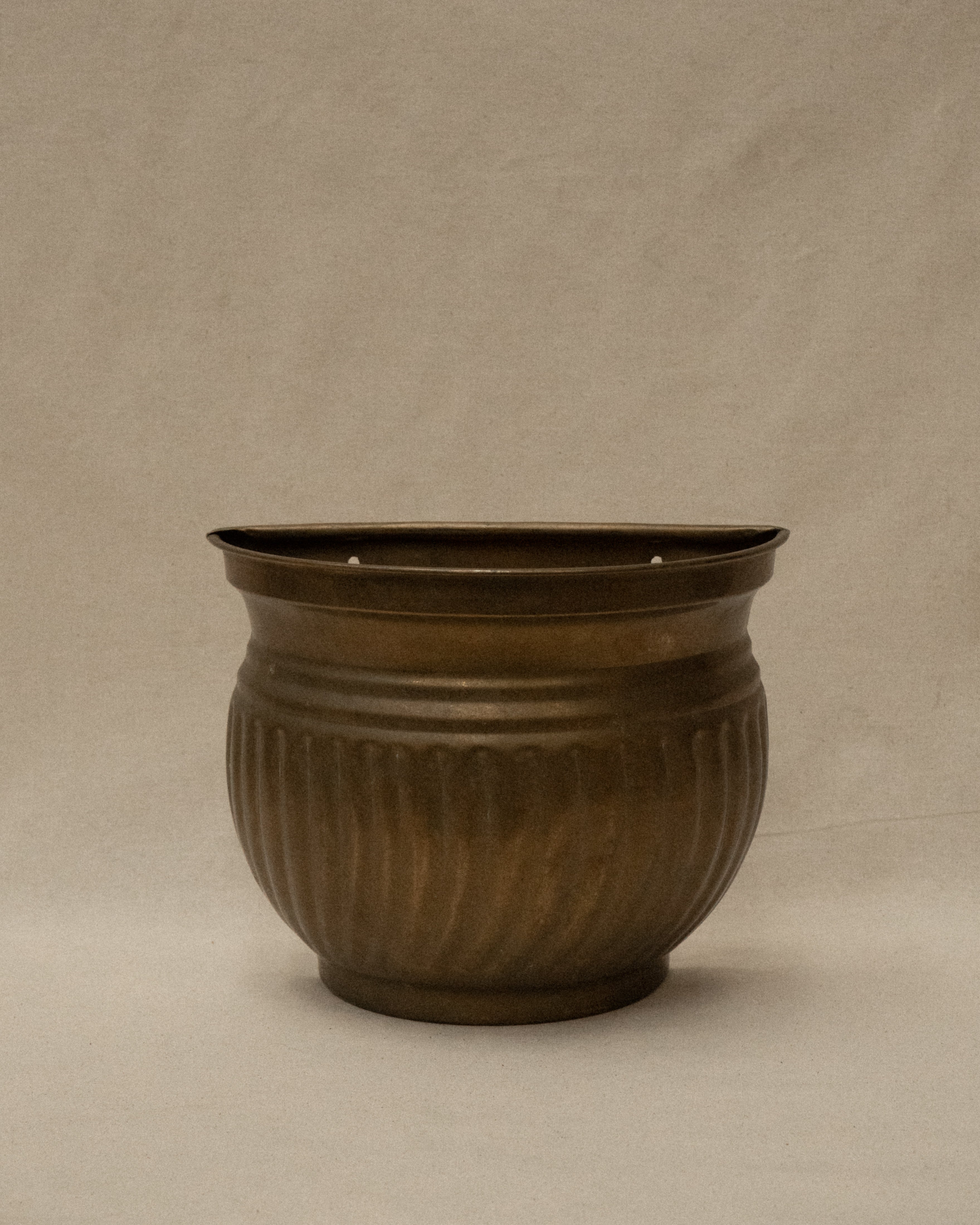 Brass plant pot that hangs on a wall