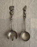 A pair of large metal serving utensils with fruit handles