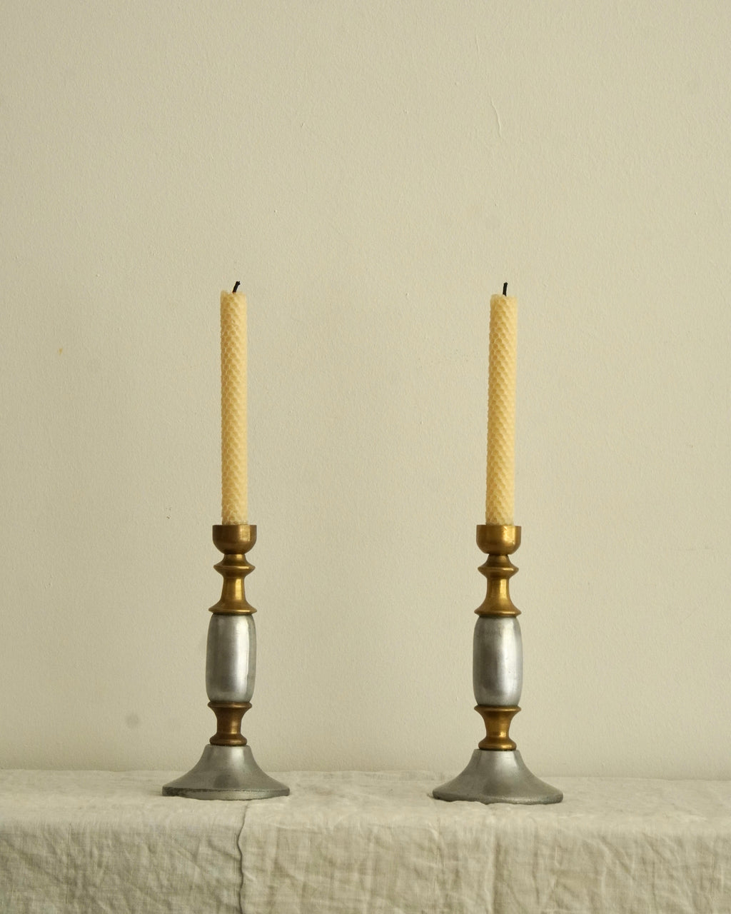 Pair of solid metal candle holders in gold and silver