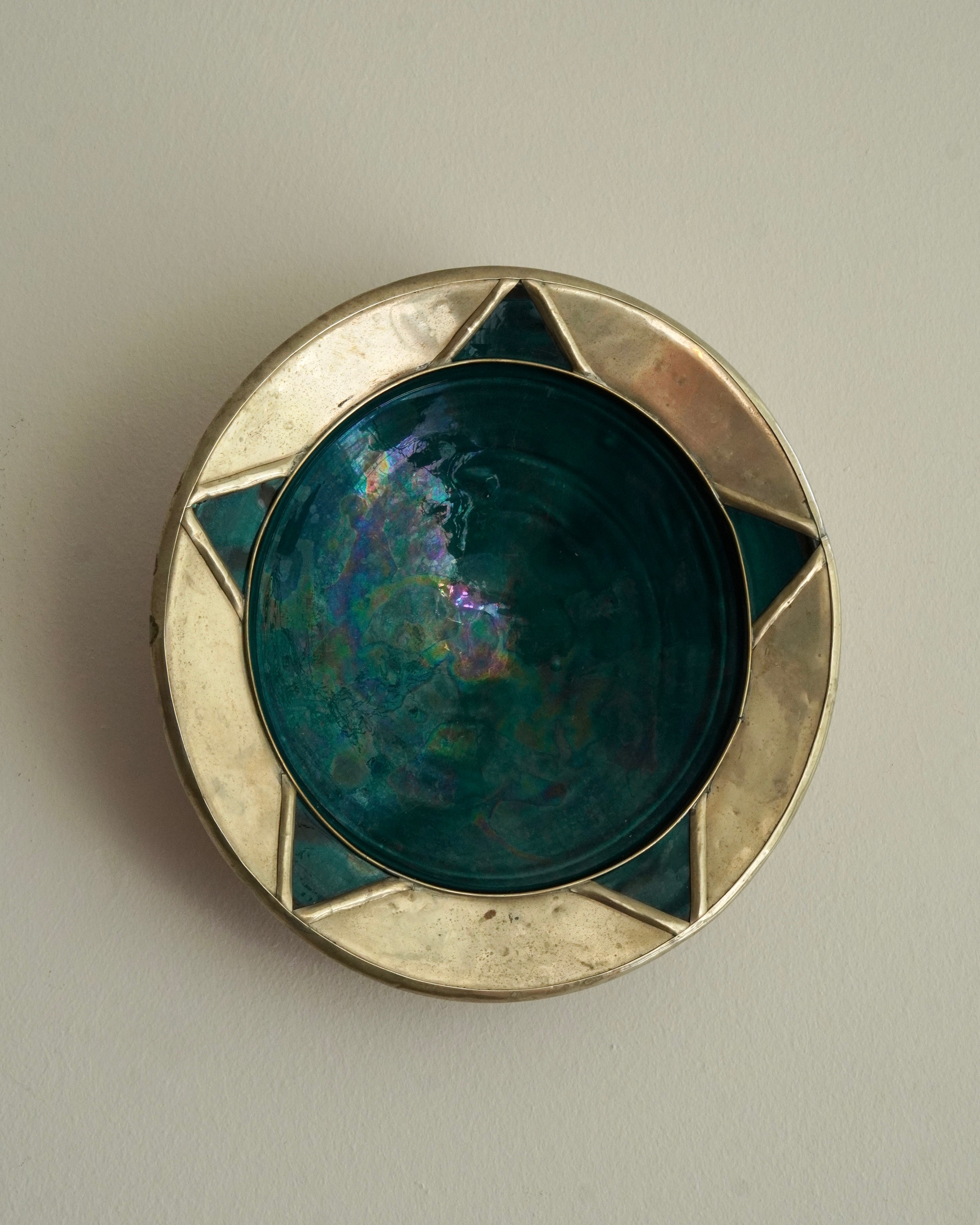 Art deco green glaze ceramic plate encased in metal wall hanging