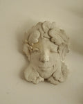 Winking concrete lady wall hanging