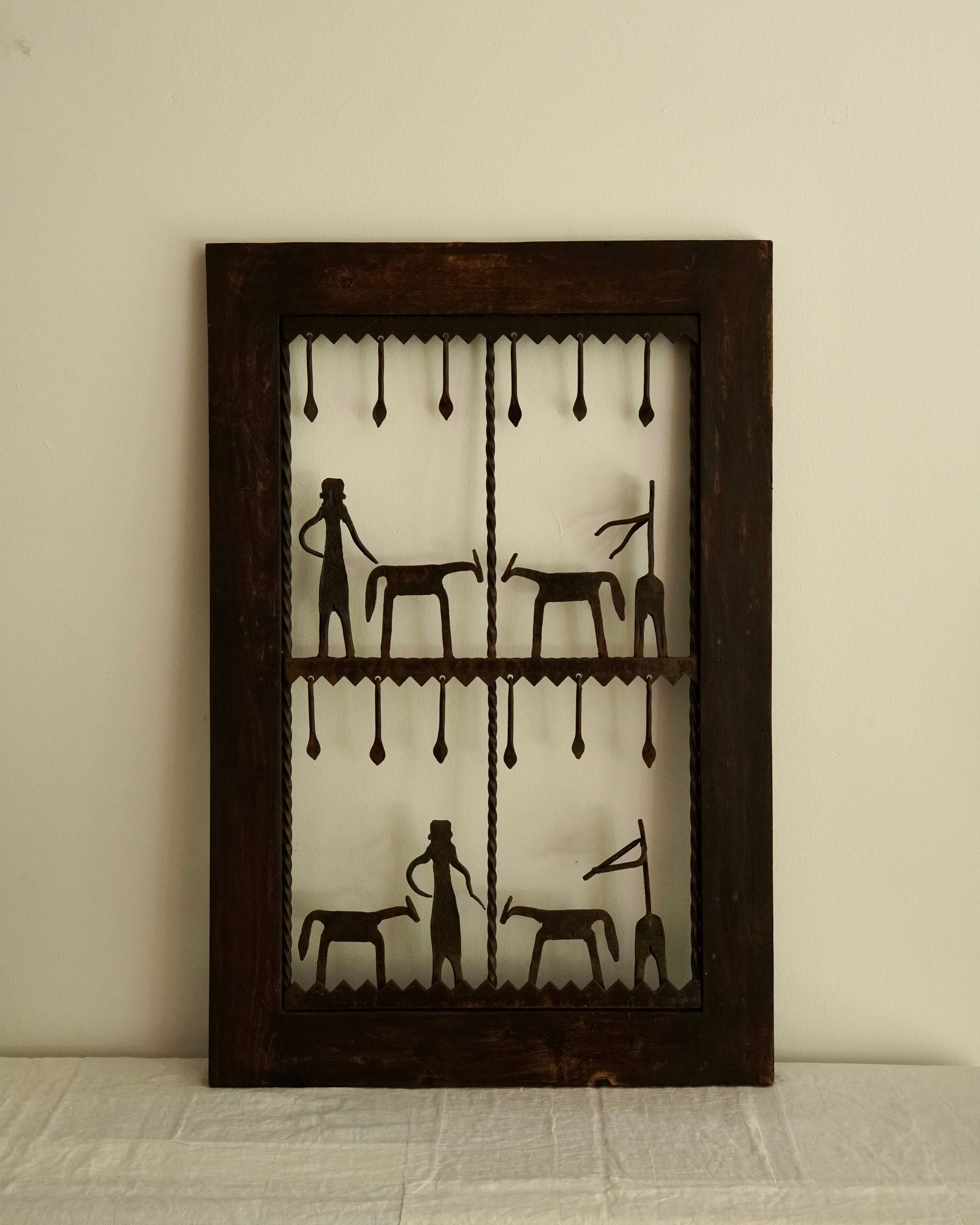 Ethnographic wall mounted panel featuring wrought iron animal and human figures
