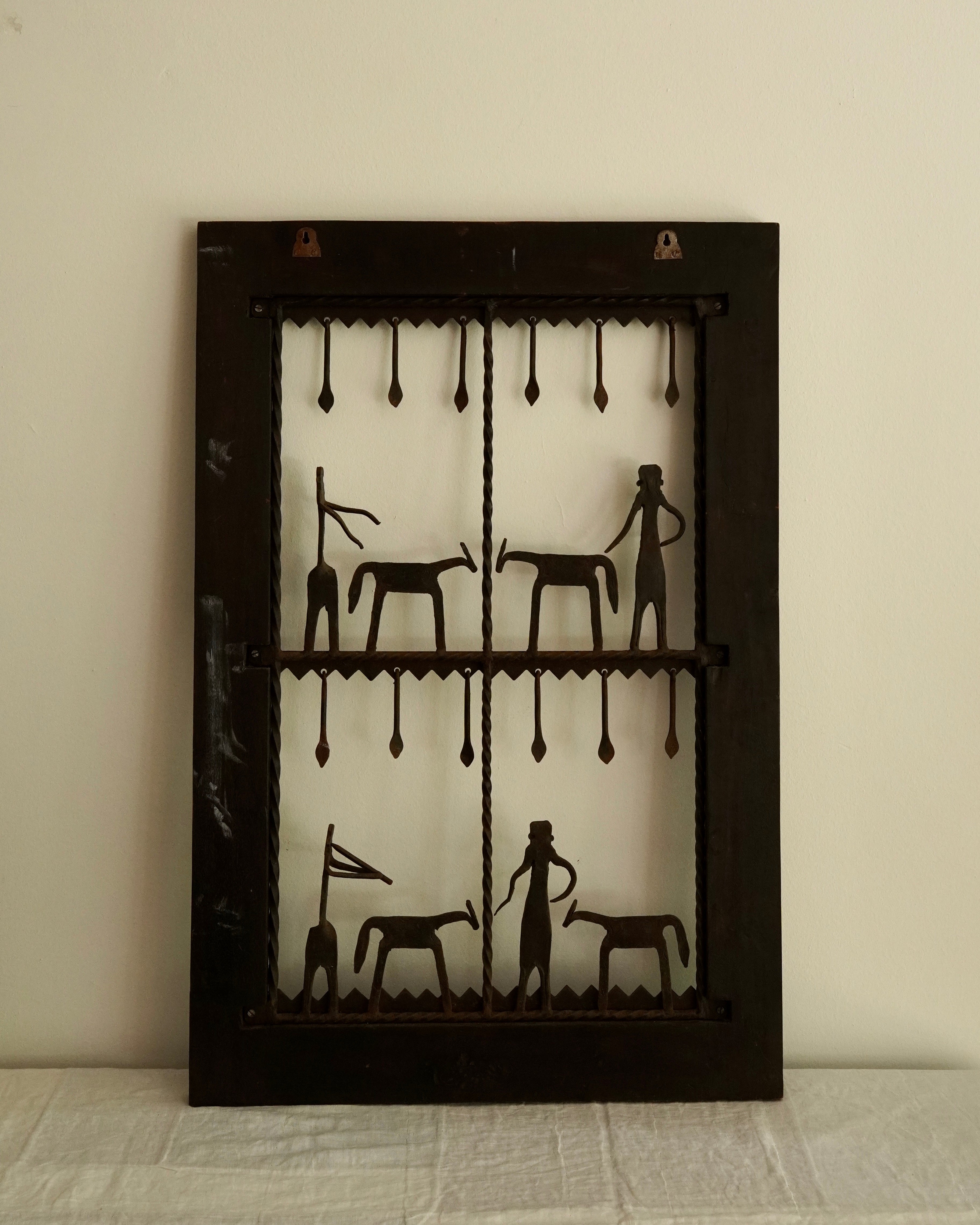 Ethnographic wall mounted panel featuring wrought iron animal and human figures